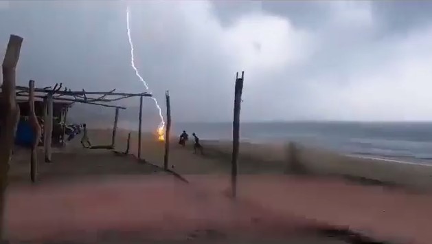 Молния бьет в воду на пляже